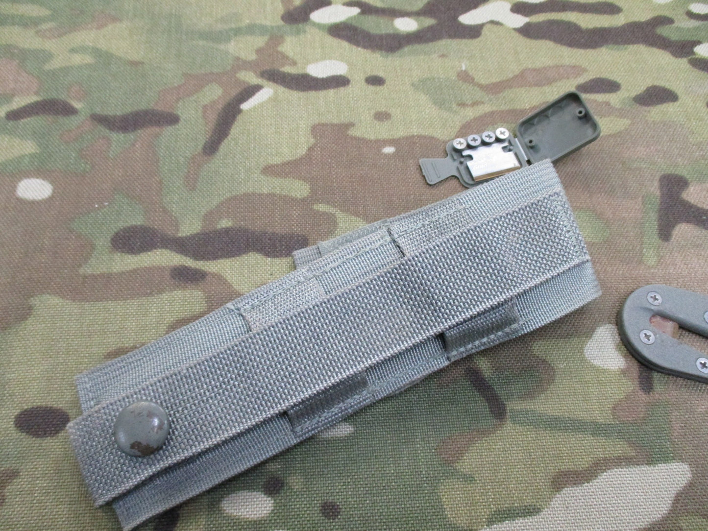 Used Ontario Knife strap and seat belt cutter with sheath, foliage design, military-style parachute knife by Centex Military Gear.
