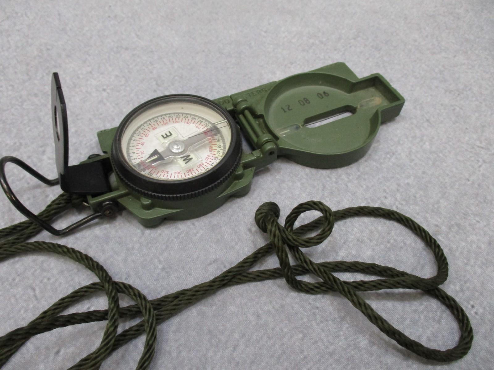 Cammenga 3H magnetic compass with phosphorescent dial and pouch, US military issue, used for accurate navigation.