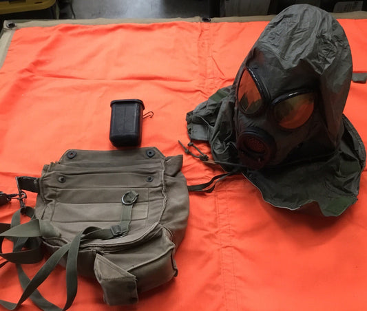 Damaged medium-sized M17 gas mask from Centex Military Gear in a display collection, showing visible wear and tear.