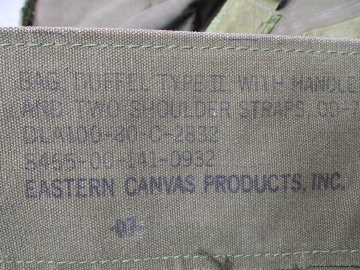 Used USGI 1980s OD green cotton canvas duffel sea bag with military surplus design and sturdy handle straps.