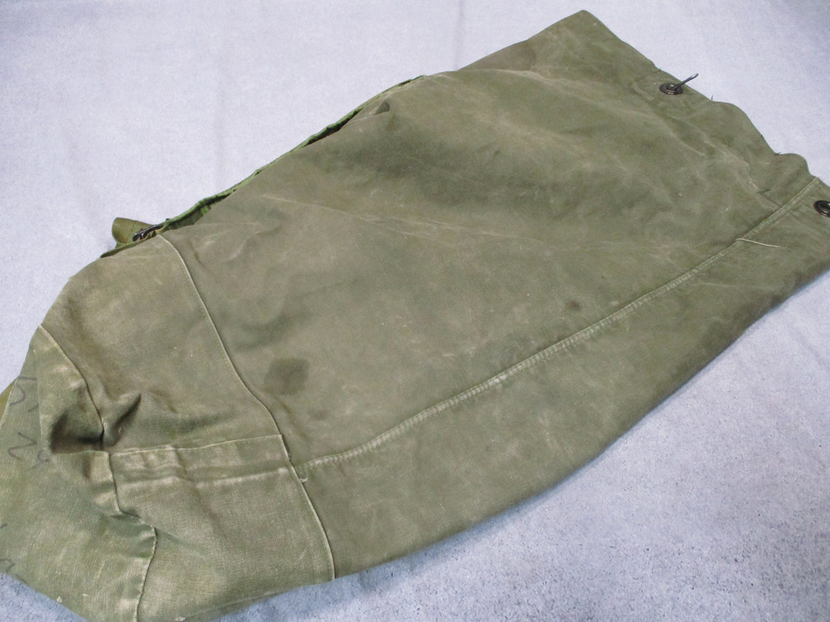 Used USGI 1980s OD Green cotton canvas duffel sea bag with military surplus design and sturdy handles.