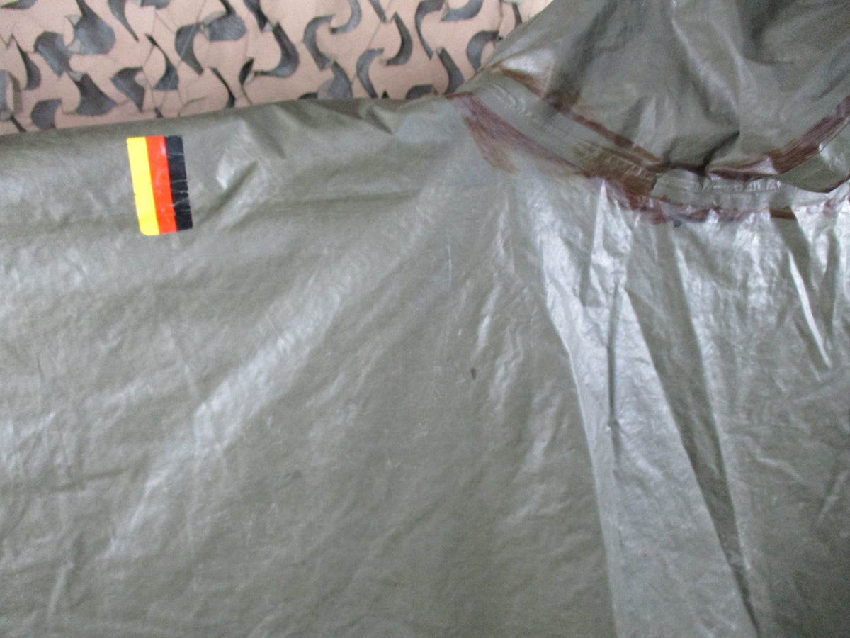 German Bundeswehr military poncho in olive green, used rain cape with shelter features and durable fabric.
