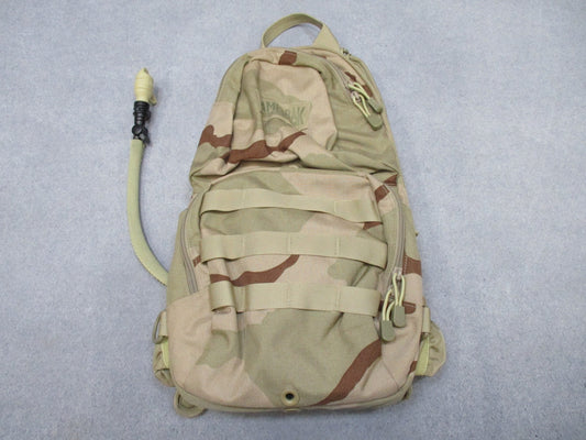 CamelBak MULE hydration pack in desert tan with tactical design and hydration carrier, shown with adjustable straps and multiple compartments.