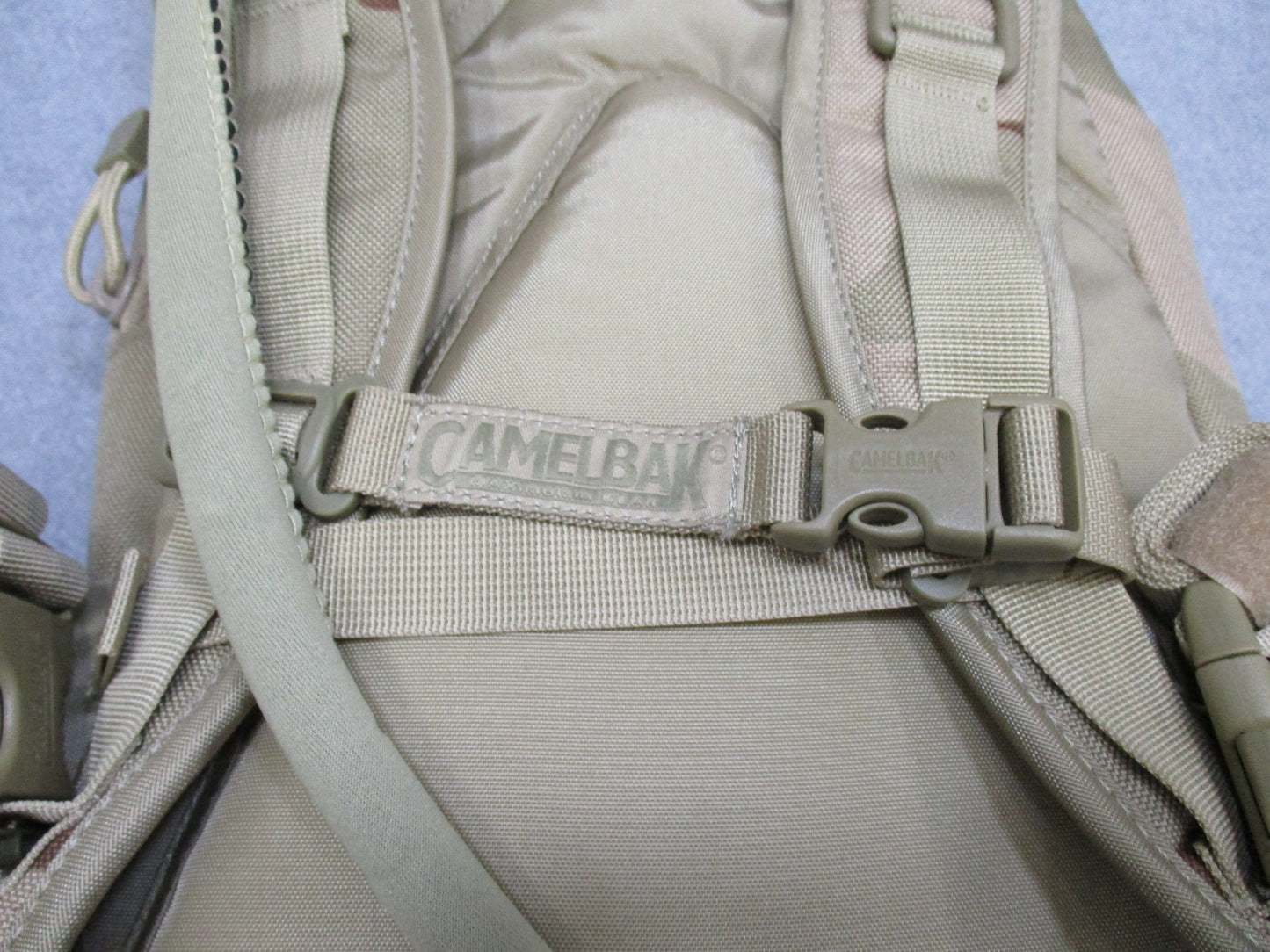 CamelBak MULE hydration pack in desert tan with tactical design, featuring hydration carrier and adjustable straps for outdoor activities.