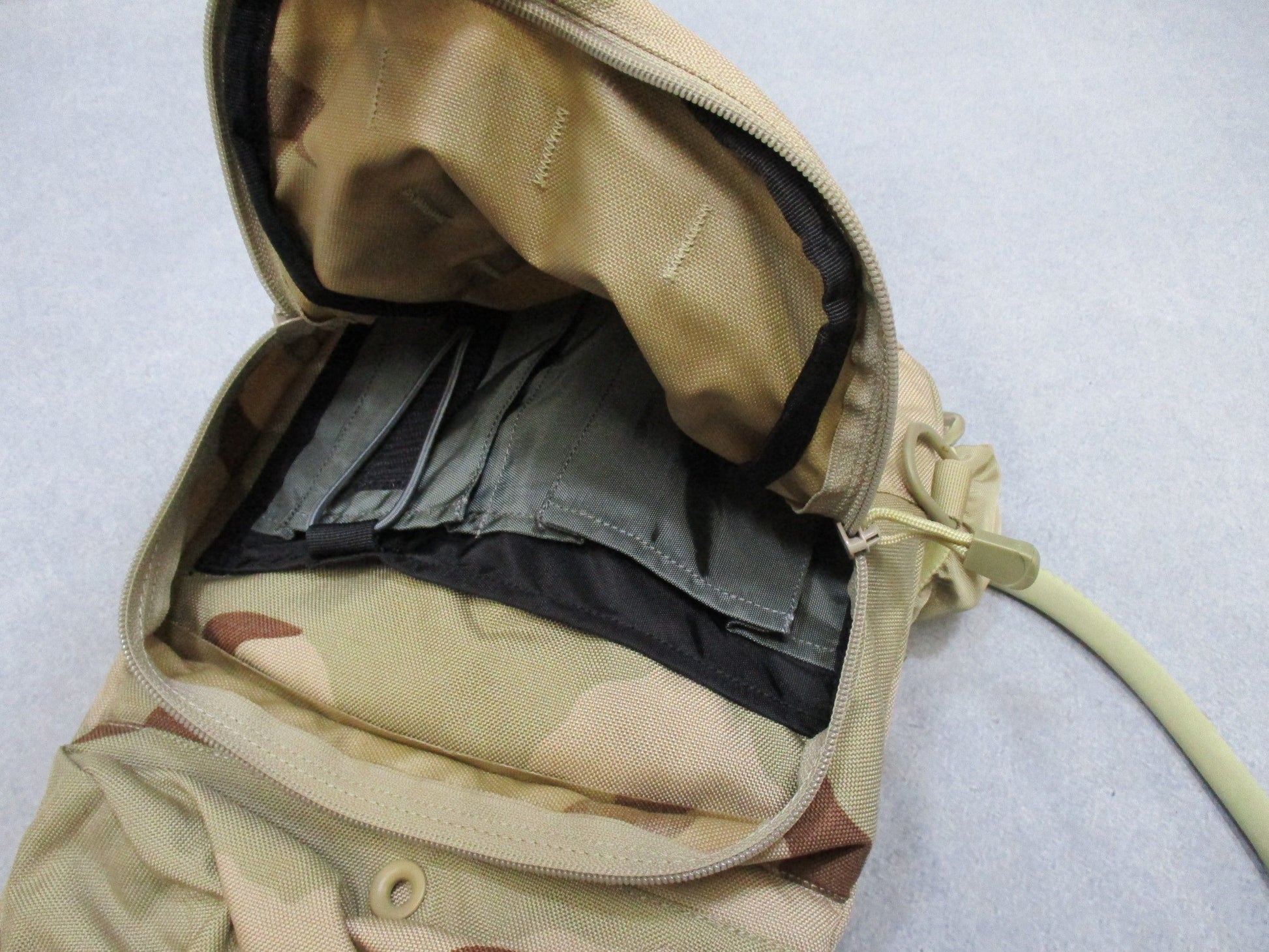 CamelBak MULE hydration pack in desert tan with tactical design, featuring adjustable straps and hydration reservoir for outdoor adventures.