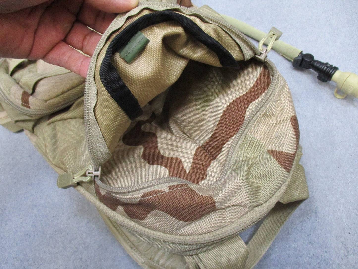 CamelBak MULE hydration pack in desert tan with tactical design, featuring hydration bladder and multiple compartments.