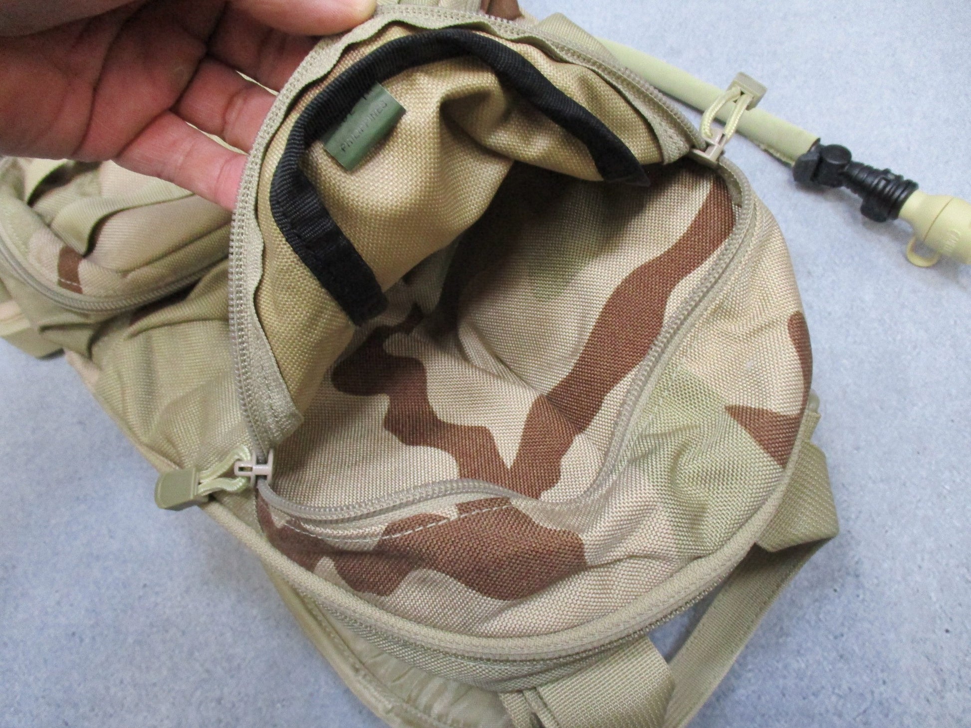 CamelBak MULE hydration pack in desert tan with tactical design, featuring hydration bladder and multiple compartments.
