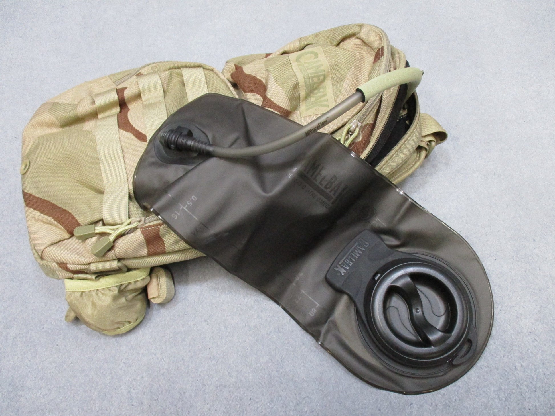CamelBak MULE tactical hydration pack in desert tan with hydration carrier and multiple compartments, designed for outdoor adventures.