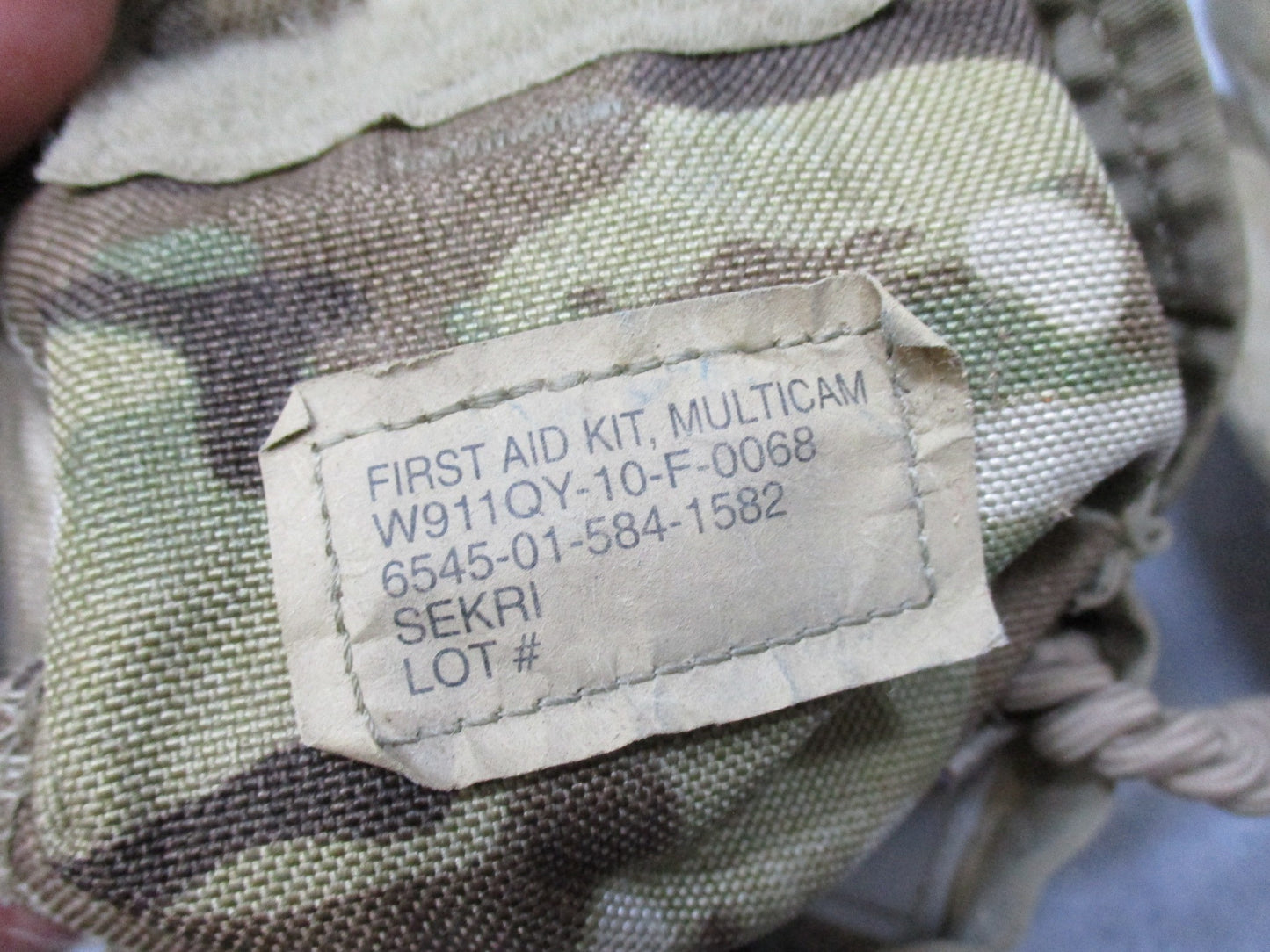 USGI Multicam IFAK pouch with expired medical supplies, military first aid kit by Centex Military Gear, showing medical contents inside.