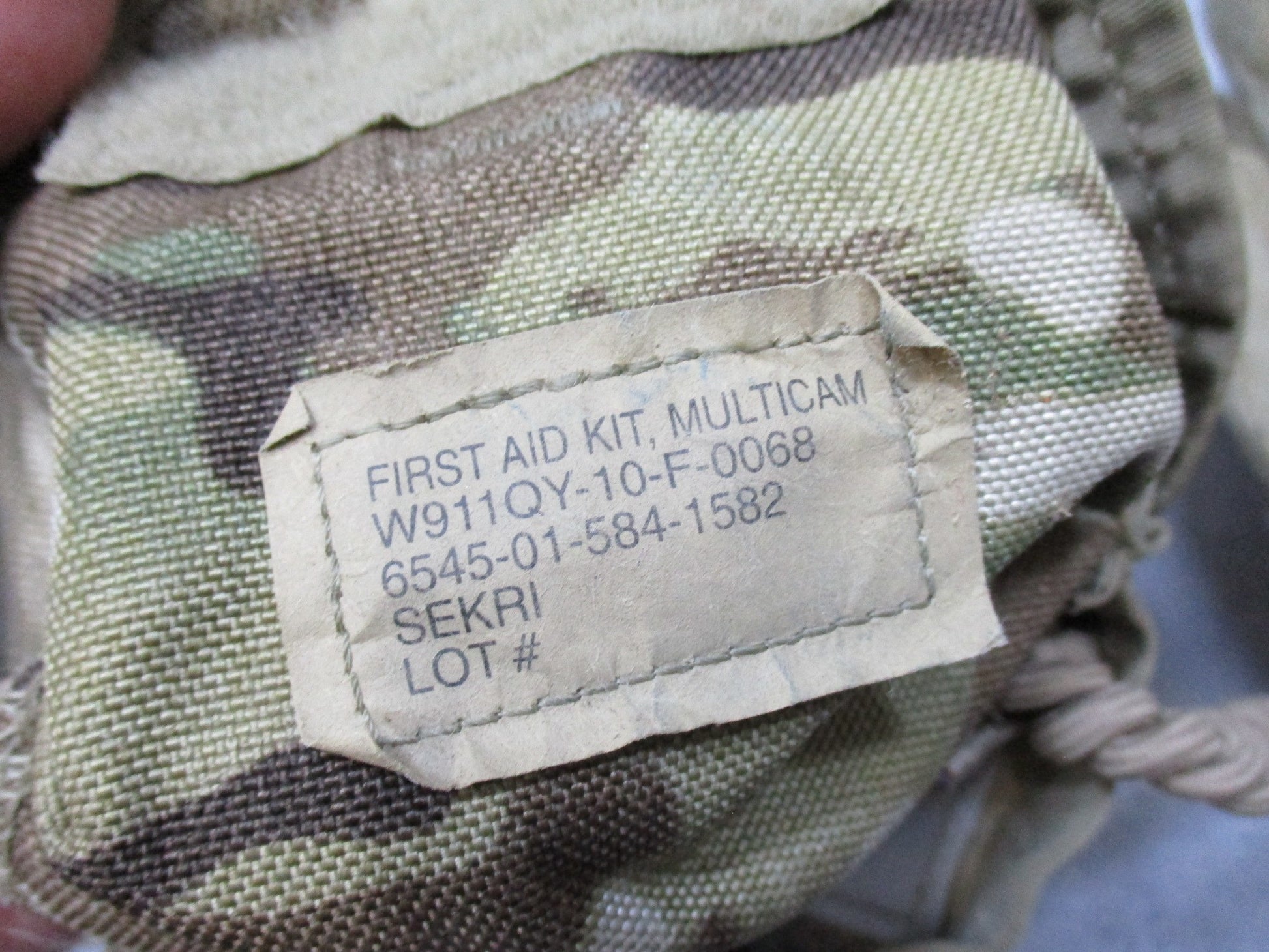 USGI Multicam IFAK pouch with expired medical supplies, military first aid kit by Centex Military Gear, showing medical contents inside.