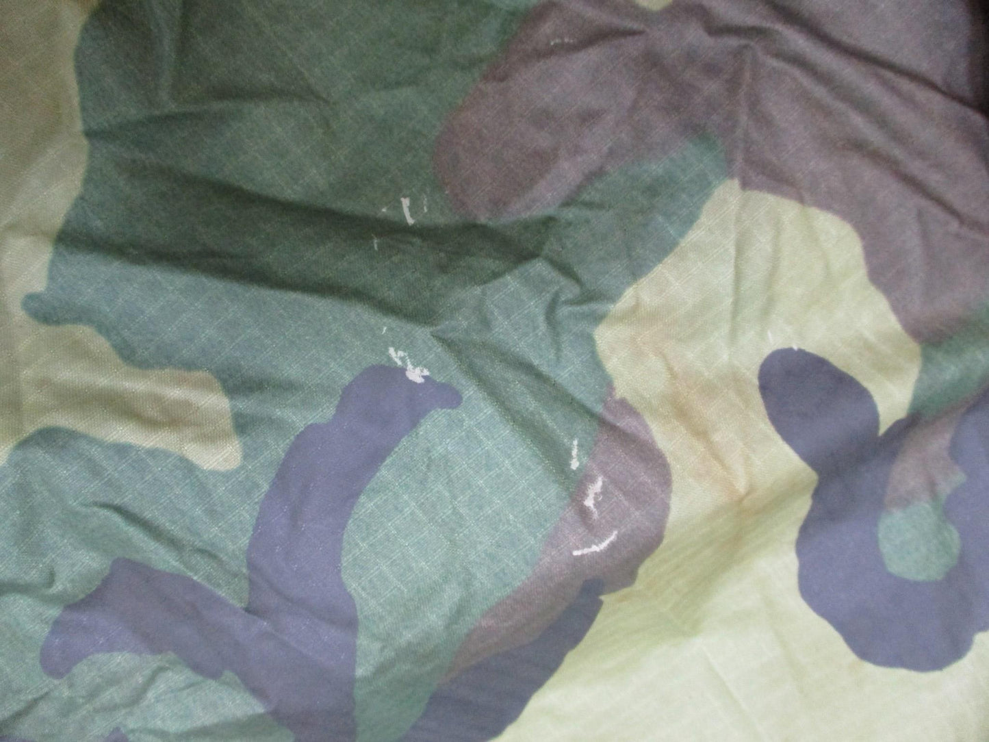 USGI military rain poncho in woodland camouflage, made from ripstop fabric, by Centex Military Gear, designed for outdoor use.