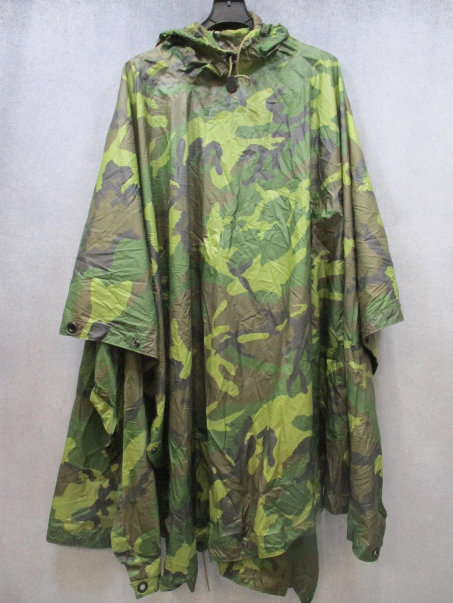 USGI military rain poncho in woodland camouflage, ripstop fabric, durable design, used for outdoor weather protection by Centex Military Gear