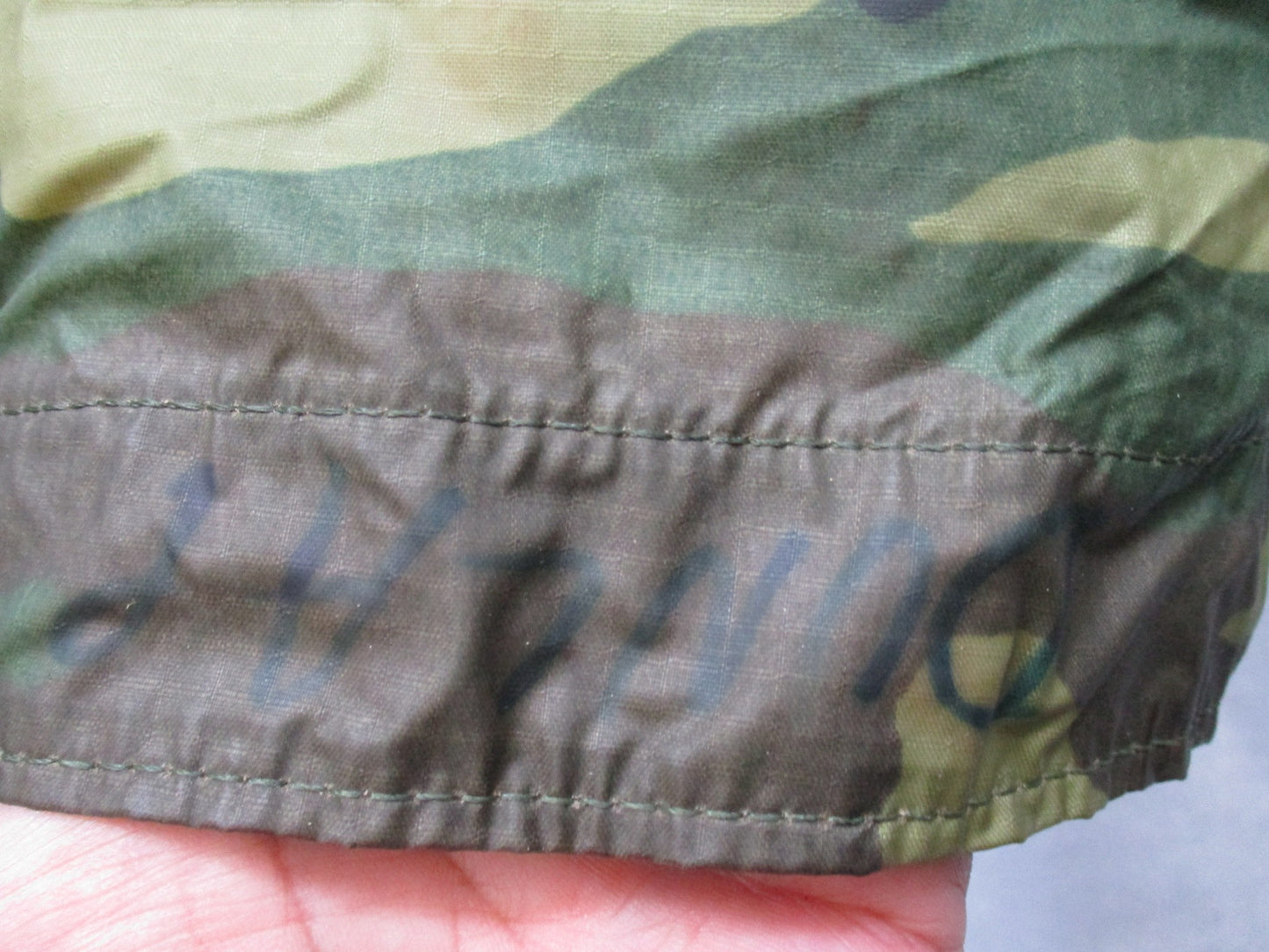 USGI military rain poncho in woodland camouflage, ripstop fabric, lightweight and durable, designed for outdoor survival and military use