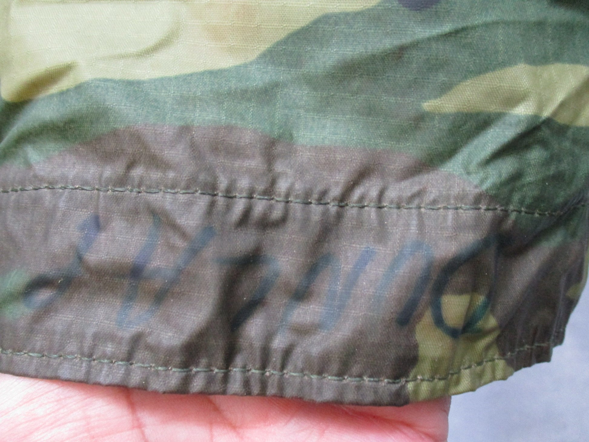 USGI military rain poncho in woodland camouflage, ripstop fabric, lightweight and durable, designed for outdoor survival and military use