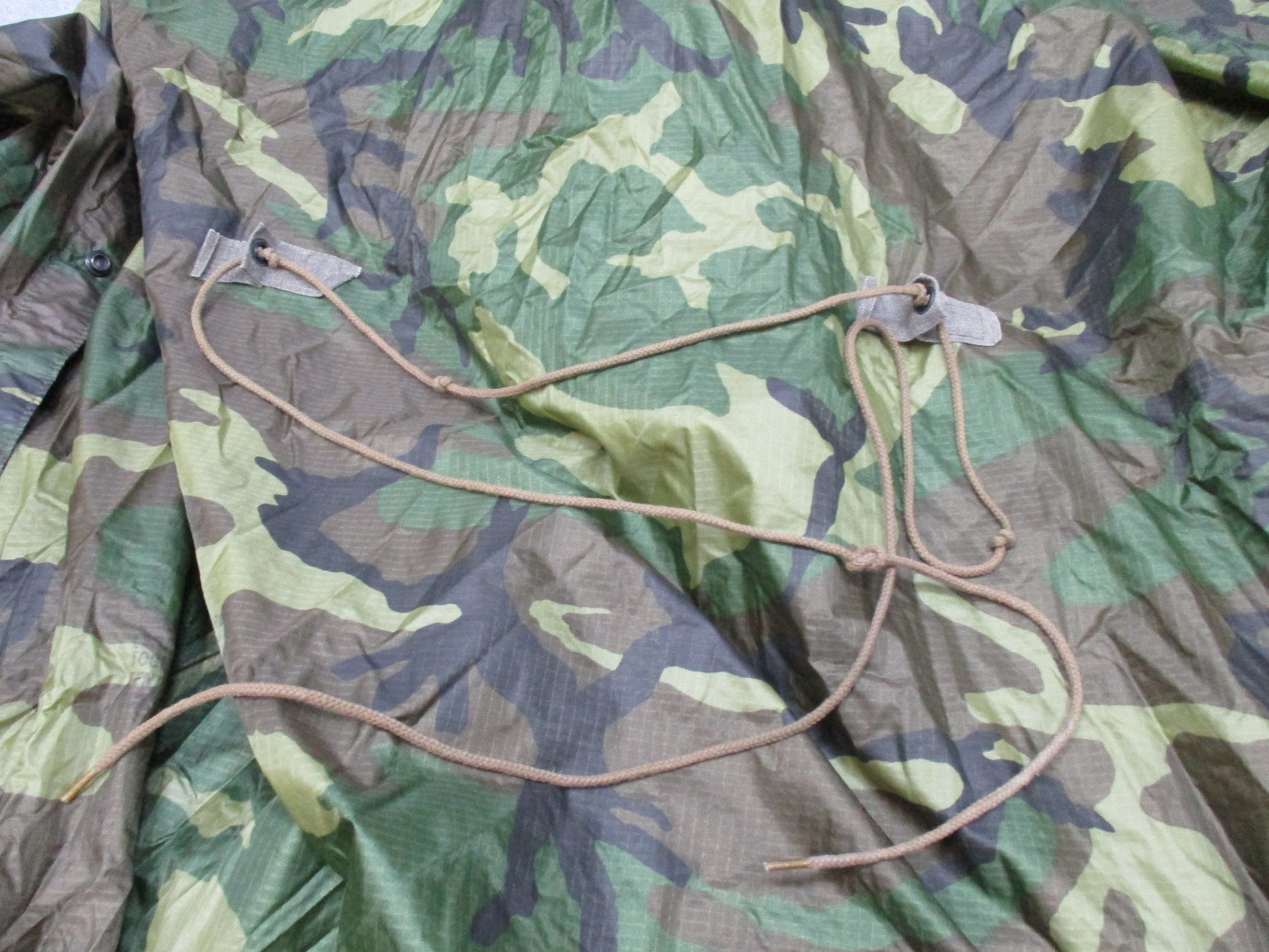 USGI military rain poncho in woodland ripstop camo, made by Centex Military Gear, designed for rain protection and outdoor use.