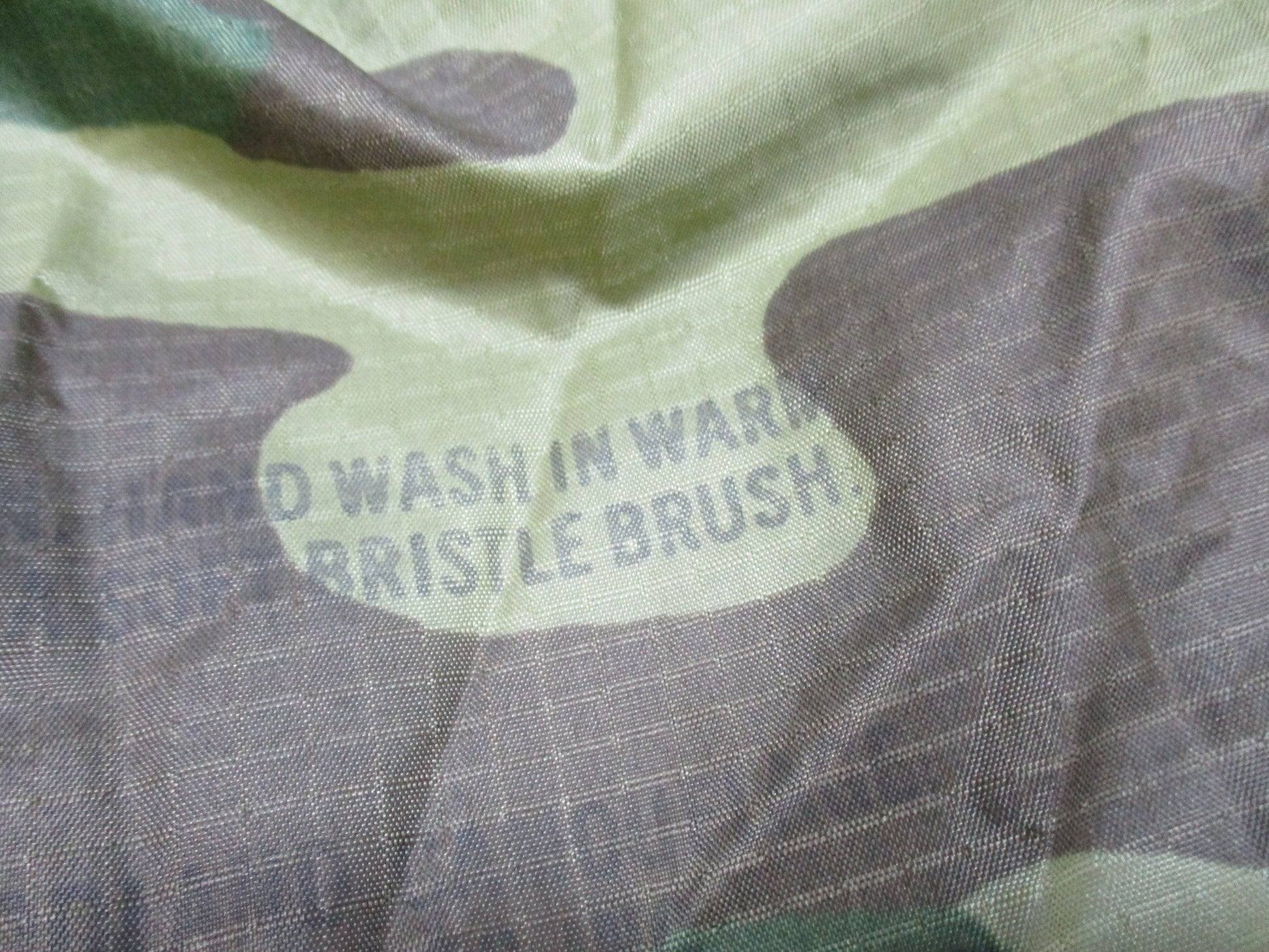 USGI military woodland rain poncho by Centex Military Gear, made of ripstop fabric with hood and reinforced seams for outdoor use.