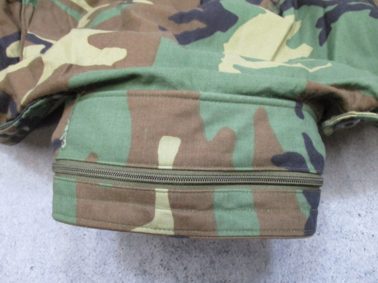 USGI M65 Field Jacket Woodland camouflage in large regular size with patches, designed for cold weather military wear.