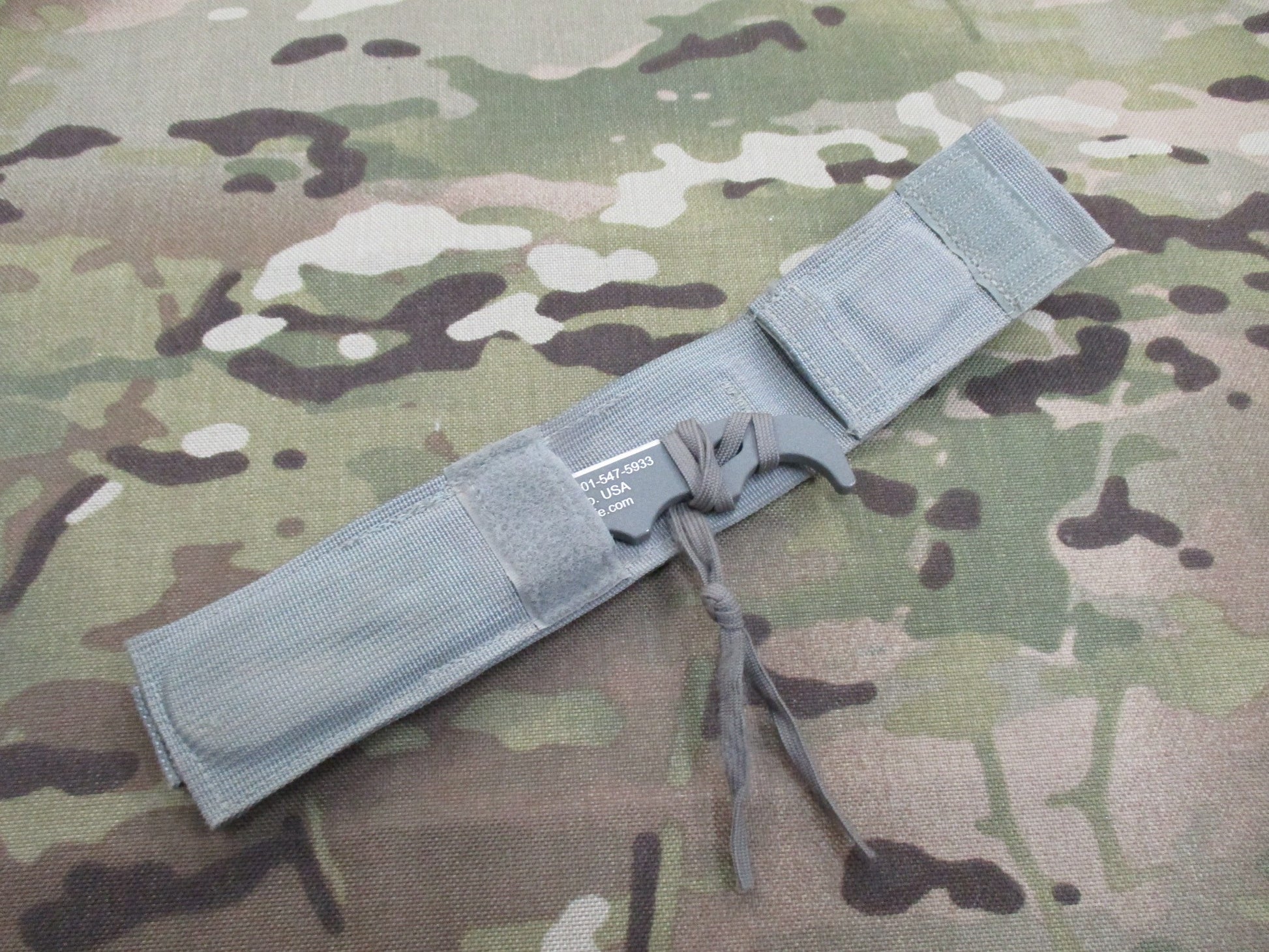 Used Ontario Knife strap and seat belt cutter with sheath, foliage design, military-style parachute knife by Centex Military Gear