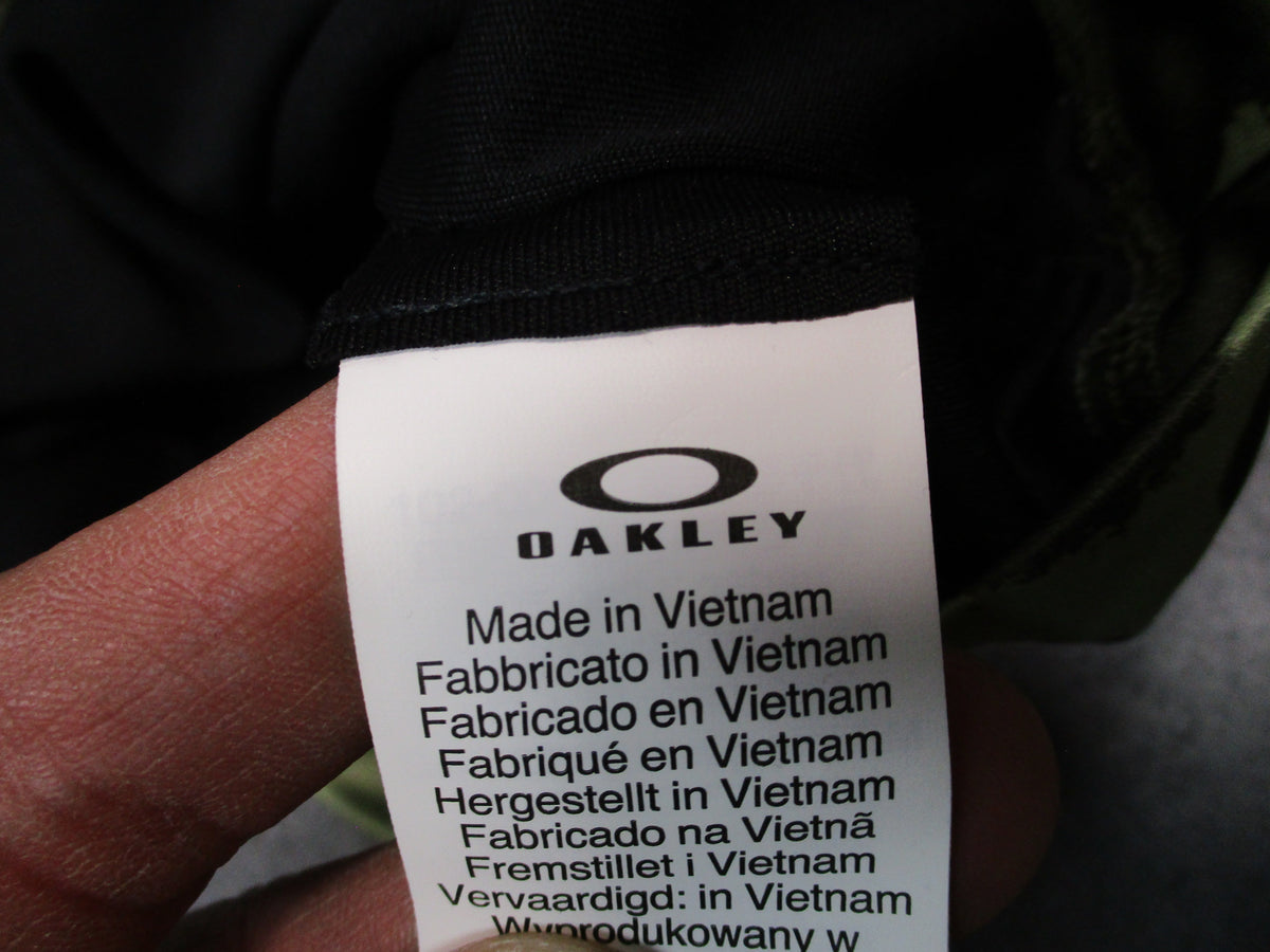 Oakley Hydrolix neck gaiter in L/XL with painted green camo pattern, FOS900712 against a white background